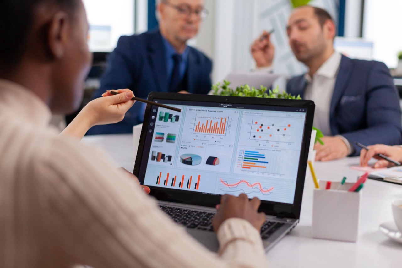 Business team reviewing an ERP analytics dashboard on a laptop during a meeting